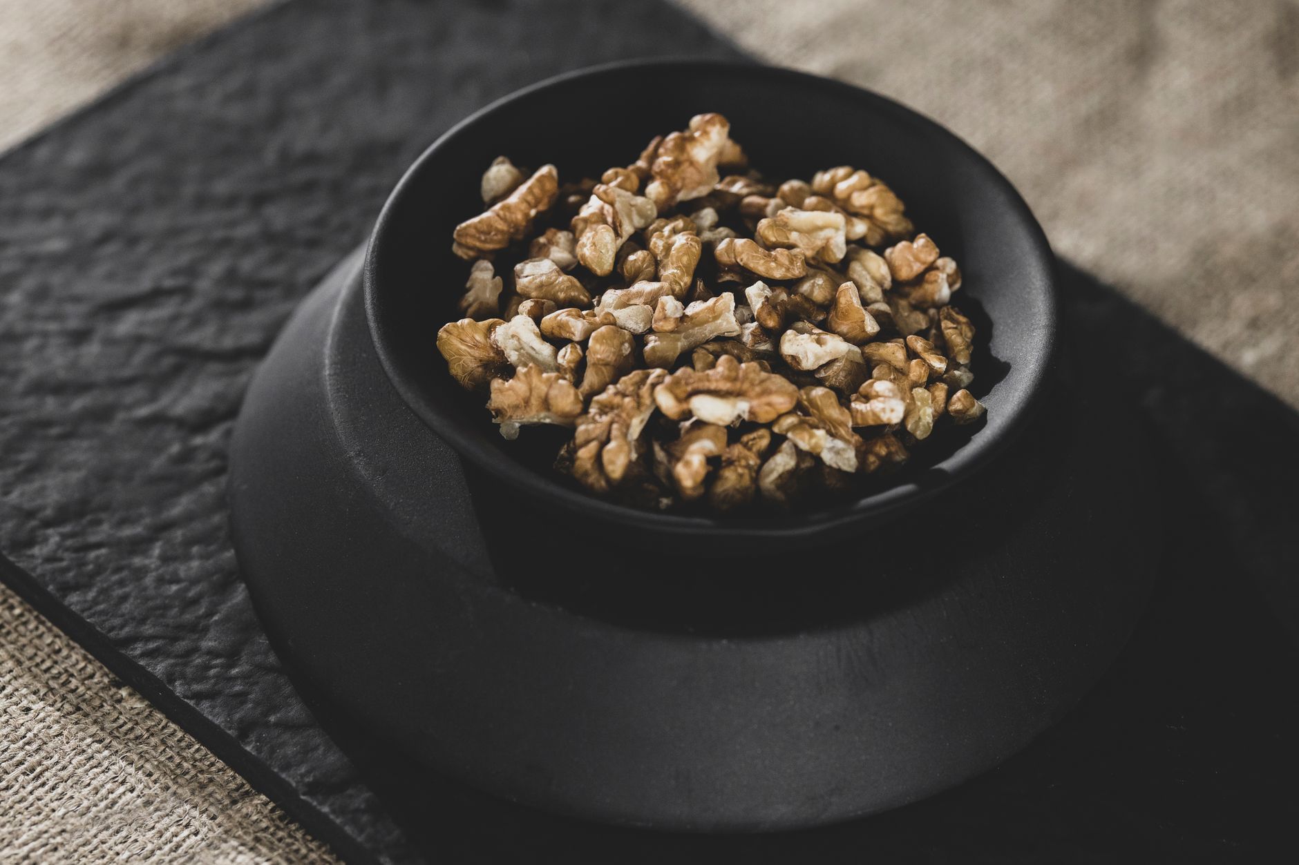 Nutritious organic walnuts in a black bowl, perfect for healthy snacks or raw diets.
