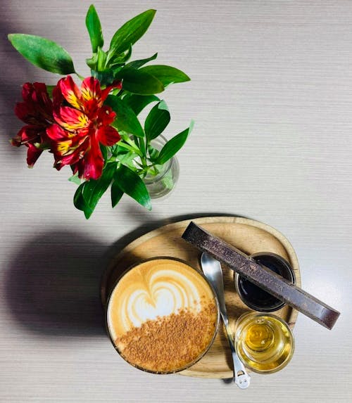 Close-Up Shot of Cup of Coffee beside a Flower Vase