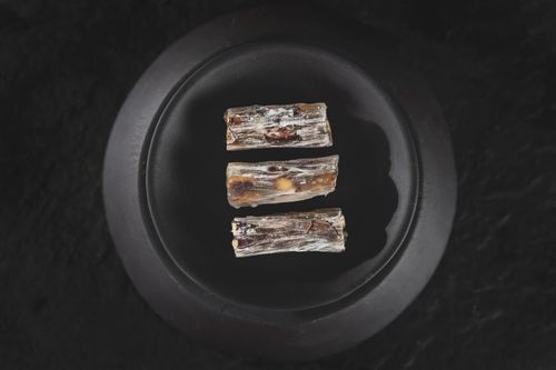 Free Three pieces of Turkish delight elegantly arranged on a black plate, captured in a minimalist style. Stock Photo