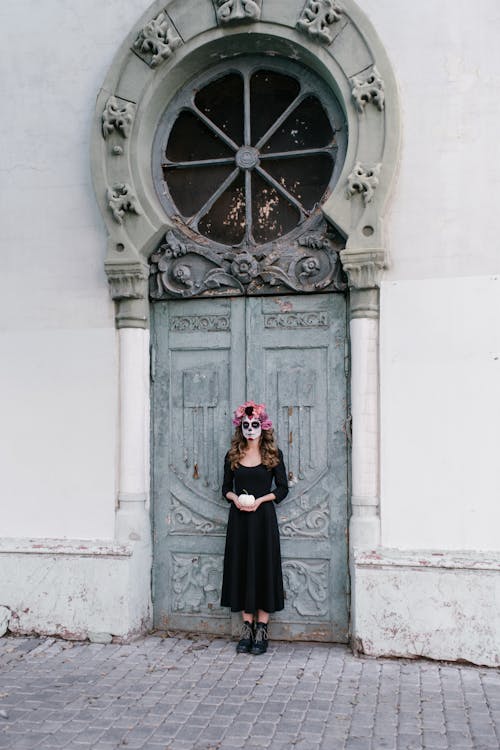 ドアの前に立っている黒いドレスの女性