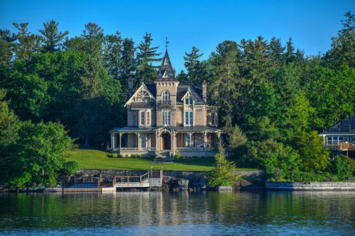 Free Stunning Victorian-style mansion by the lake surrounded by lush greenery in Joyceville, Ontario. Stock Photo