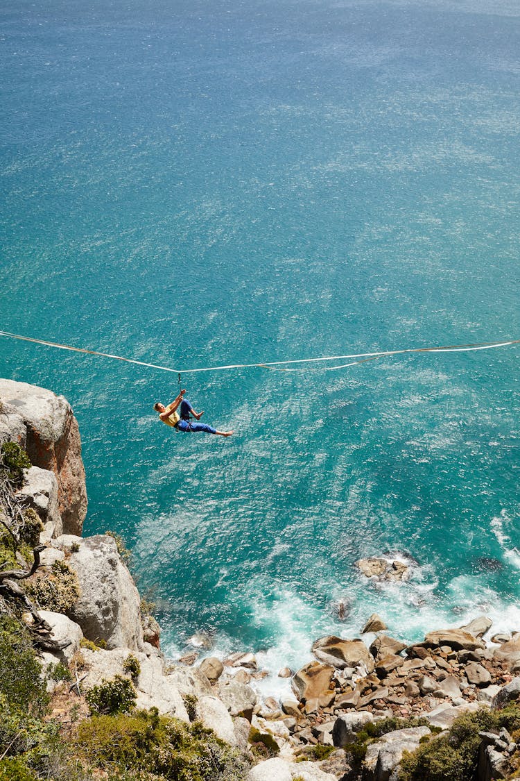 Woman Hanging On Zipline Over Seashore