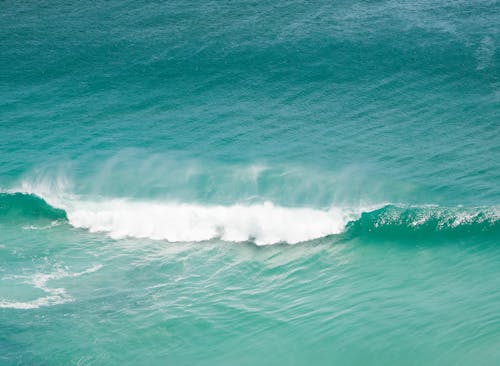 High angle of foamy ocean waves rolling on turquoise rippling pure water surface