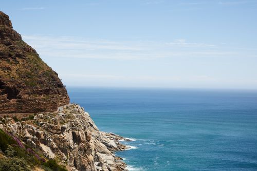 Free Amazing view of turquoise foamy rippling water of sea washing stony coast with rough rocky formation against blue sky Stock Photo