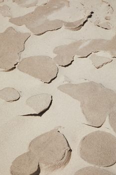 From above of ground covered with sand of different textures in desert in daytime
