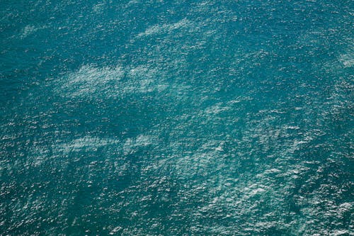 Drone view of rippling azure pure water of sea with little waves running on surface