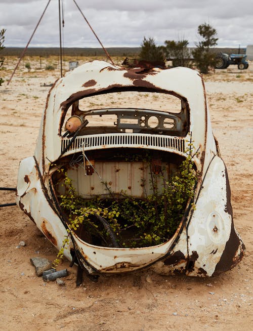 Abandoned broken car in sandy terrain