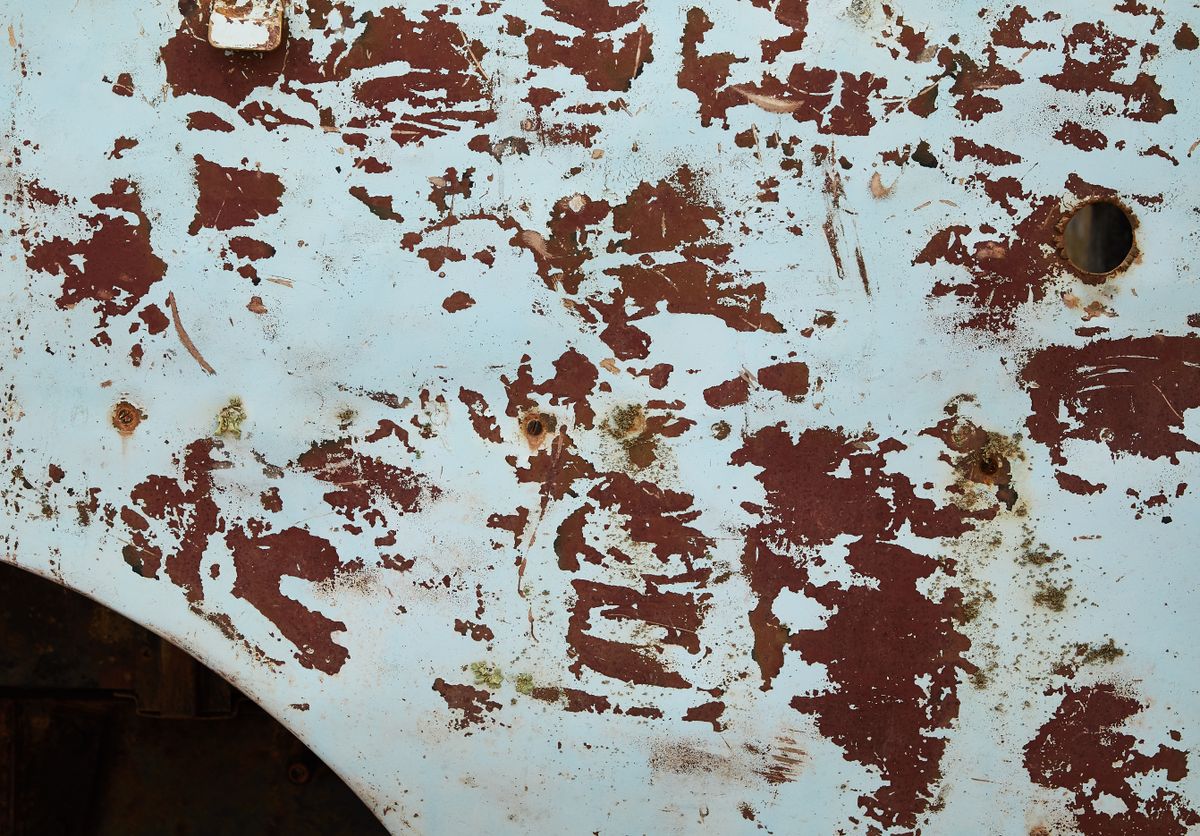 A weathered, scratched painted surface — the kind of wear that damages printed codes