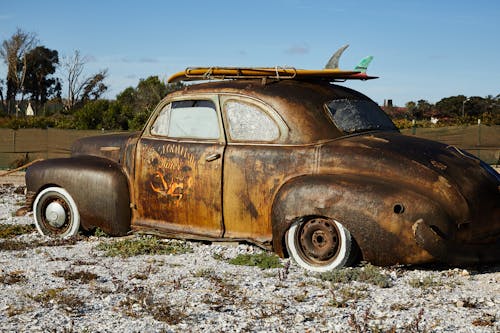 Vintage rusty broken car on gravel