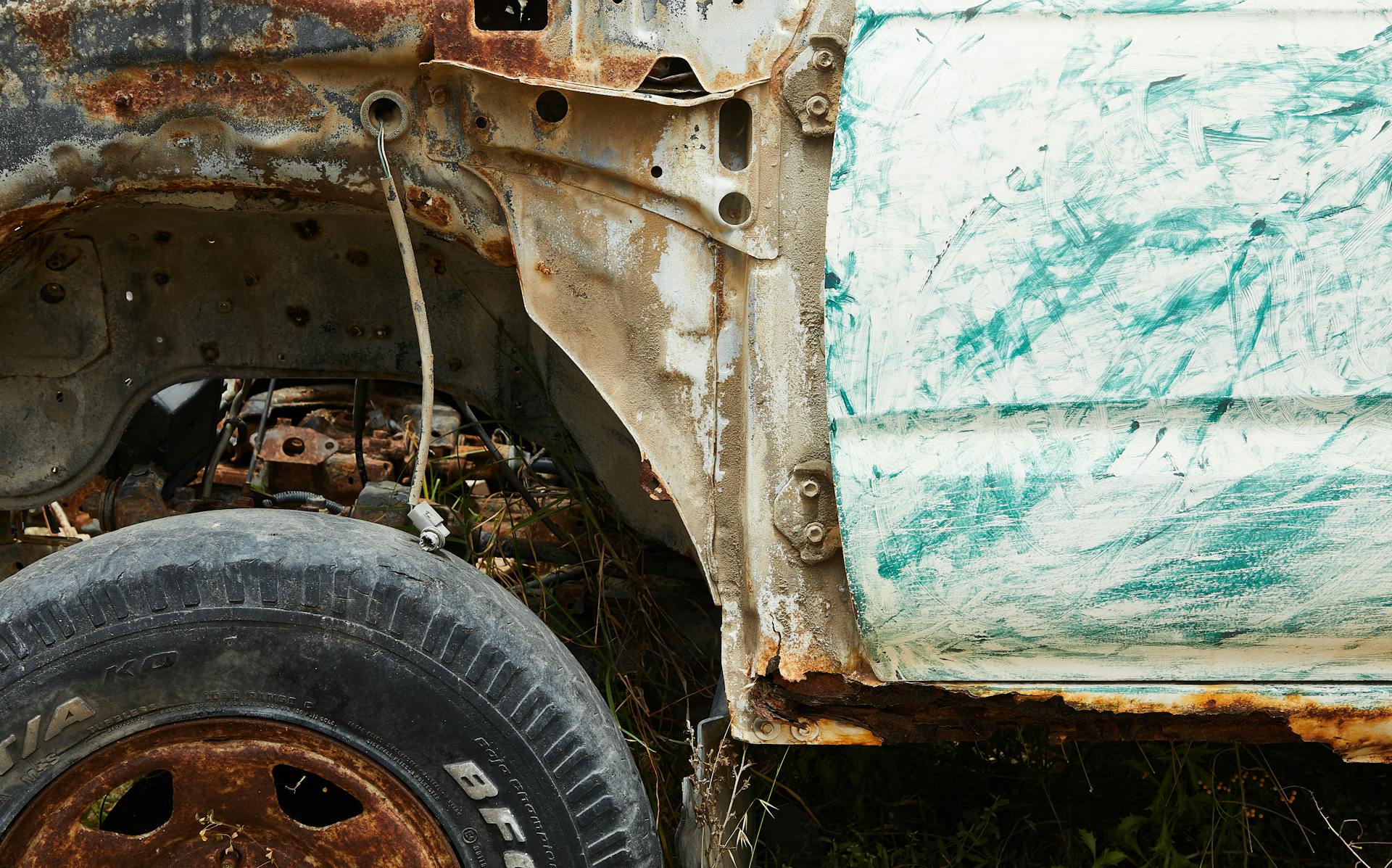 Aged metal rusty damaged car on grass