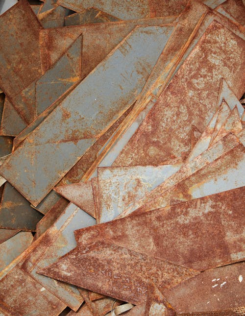Free Top view of aged iron segments covered with rust placed in heap in workshop Stock Photo