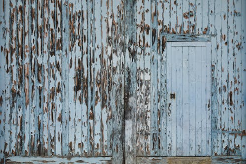 Free Entrance of aged damaged abandoned wooden warehouse with peeling white paint on wall Stock Photo