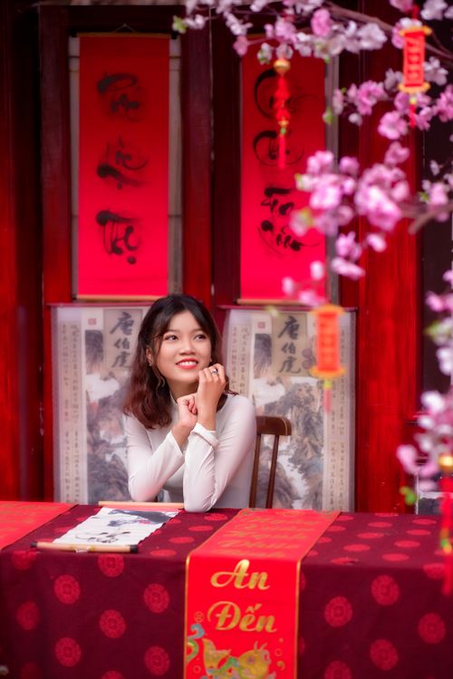 Free A woman in a traditional setting surrounded by vibrant colors and blossoms, captured indoors. Stock Photo