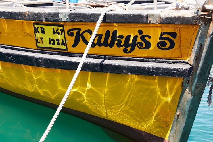 Bright Yellow Boat With Rope In Turquoise Water Of Ocean