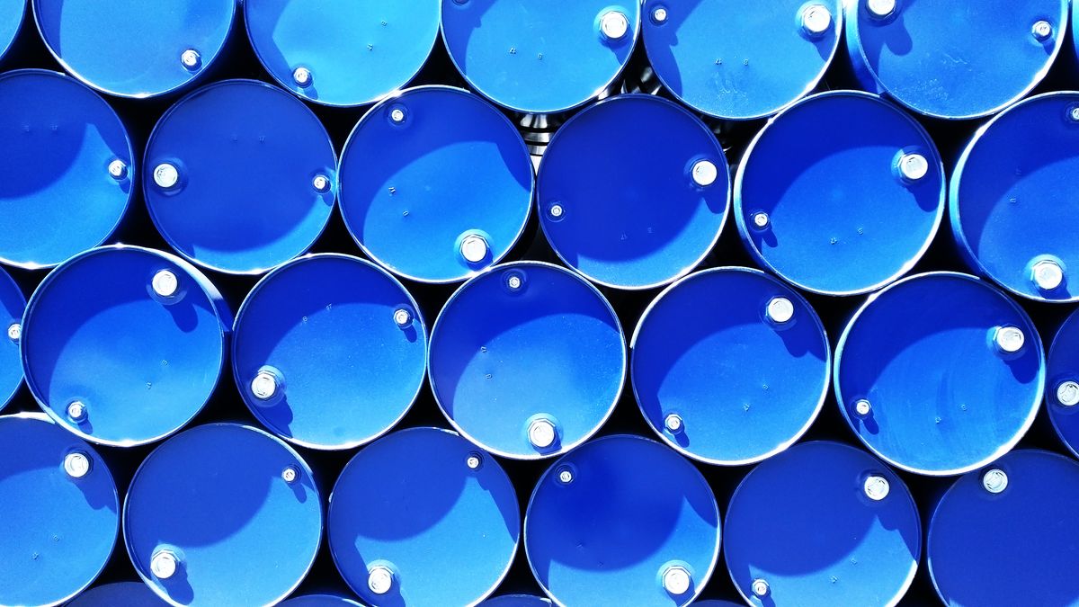 Blue industrial chemical drums stacked in a warehouse storage facility