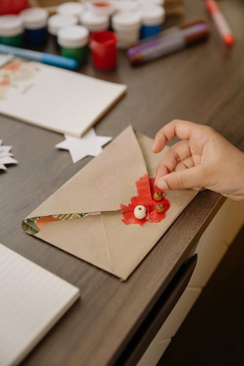 Close-Up View of a Person Putting Stamp on Envelope