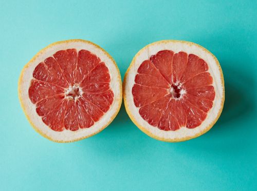Free High angle of composition of halves of sliced juicy grapefruit against blue background in studio Stock Photo