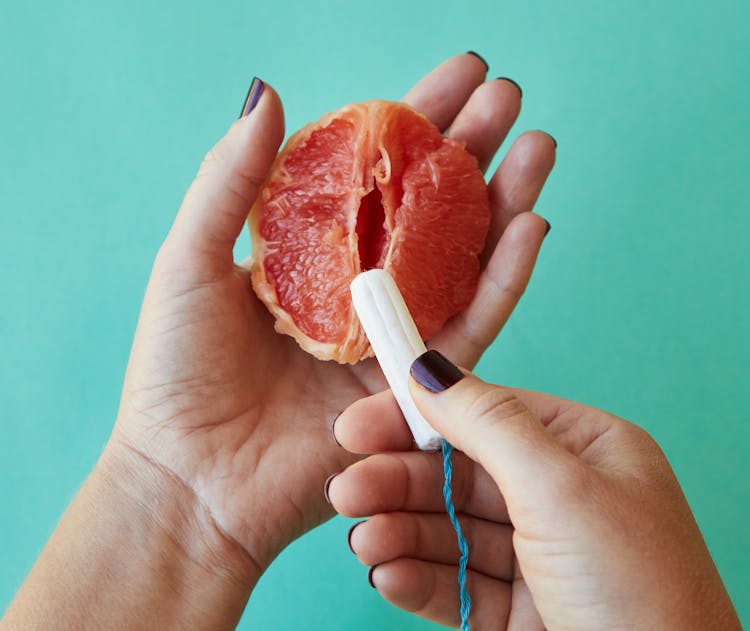 Woman Holding Ripe Grapefruit And Feminine Tampon