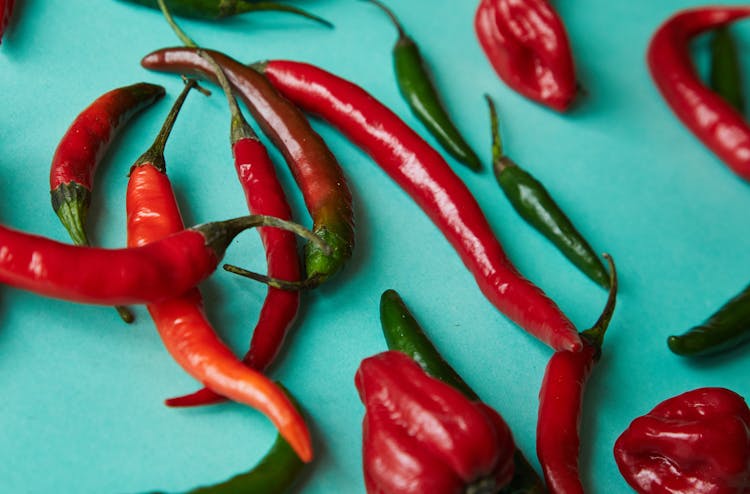 Sweet And Chili Red And Green Peppers Placed On Light Blue Desk