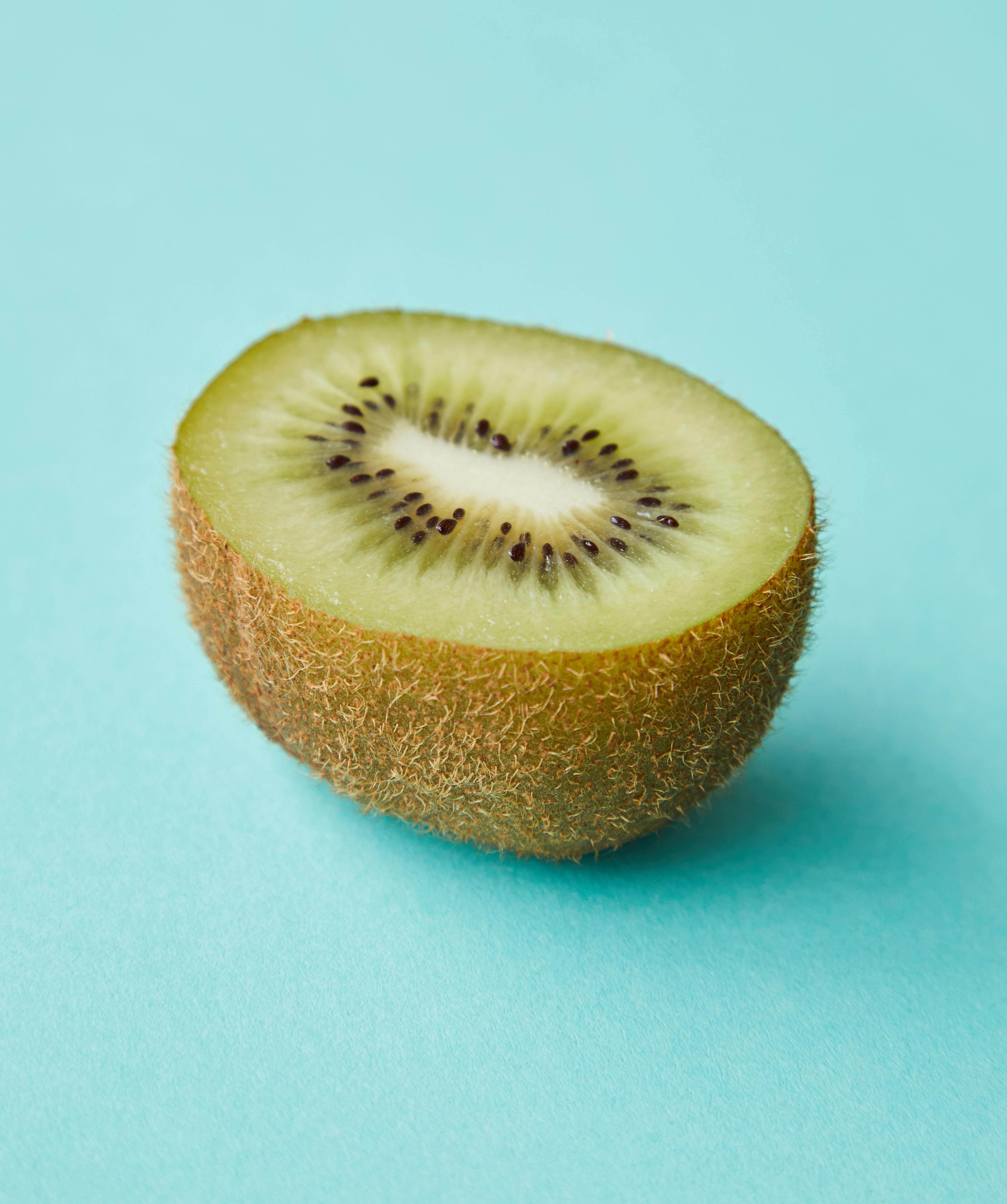 cut juicy kiwi on blue surface