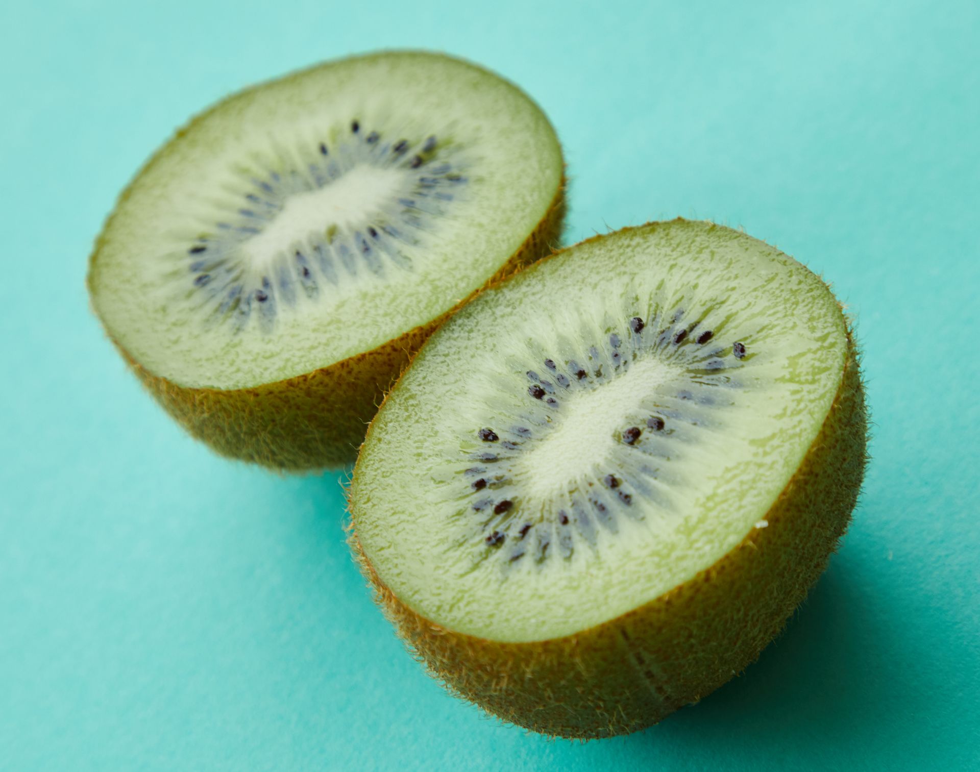 Halves of ripe kiwi on blue background