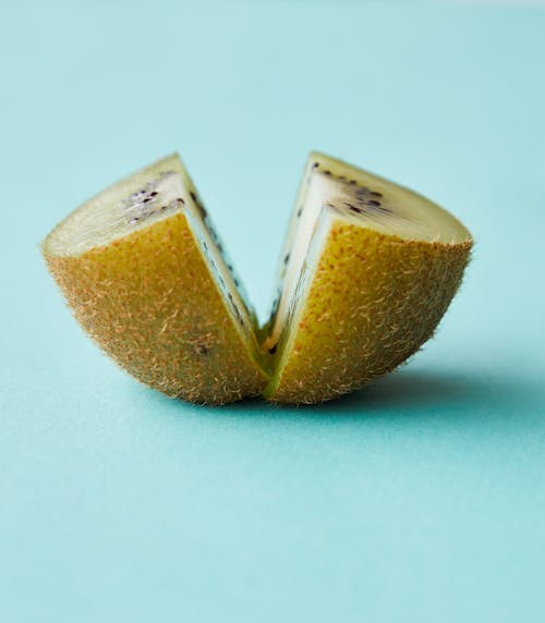 Quarters of fresh kiwi on blue background