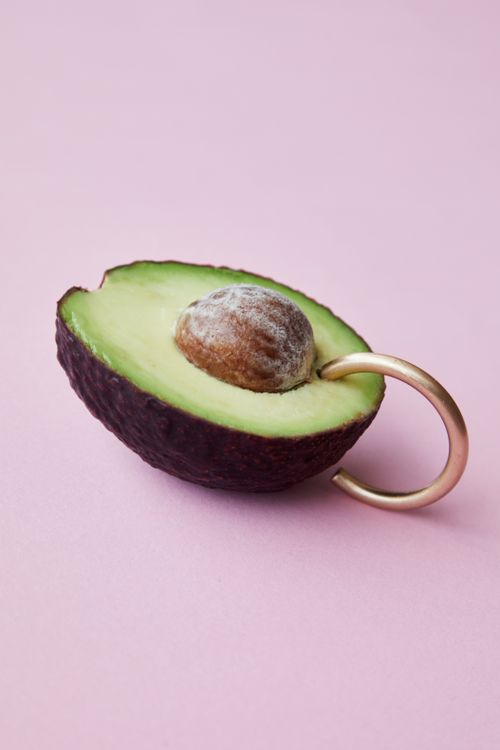 Free High angle of half of fresh ripe green avocado with seed and small metal hook in pulp Stock Photo