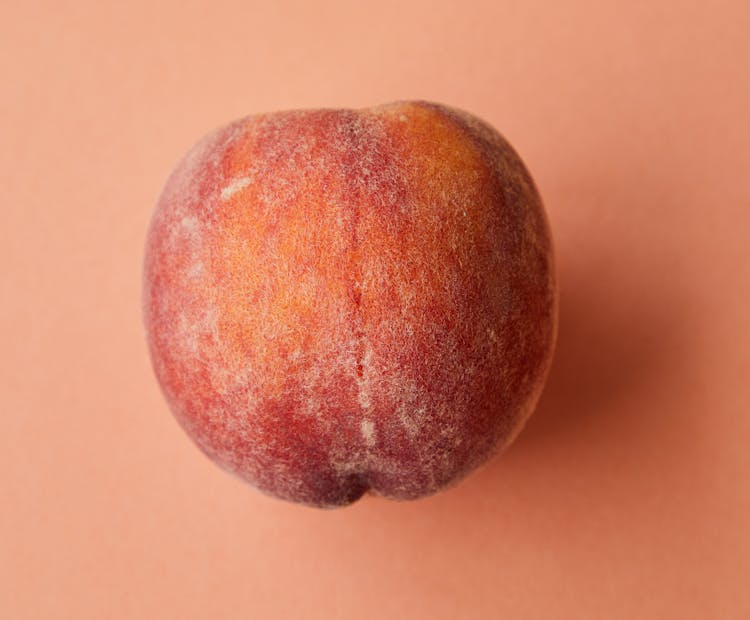 Fresh Juicy Pink Peach On Pink Surface