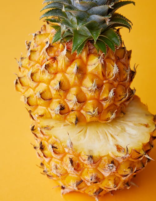 Fresh juicy pineapple arranged on yellow background