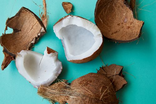 Free Top view of pieces of fresh ripe coconut with soft fragrant white pulp placed on blue background Stock Photo