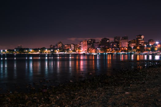 Stunning view of İstanbul's skyline at night reflecting vibrant city lights on the calm waters.