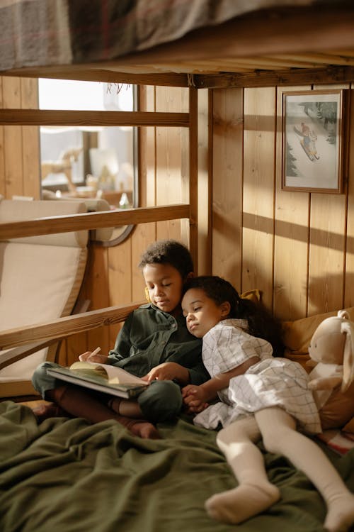 A Girl Watching Her Brother Write on a Book