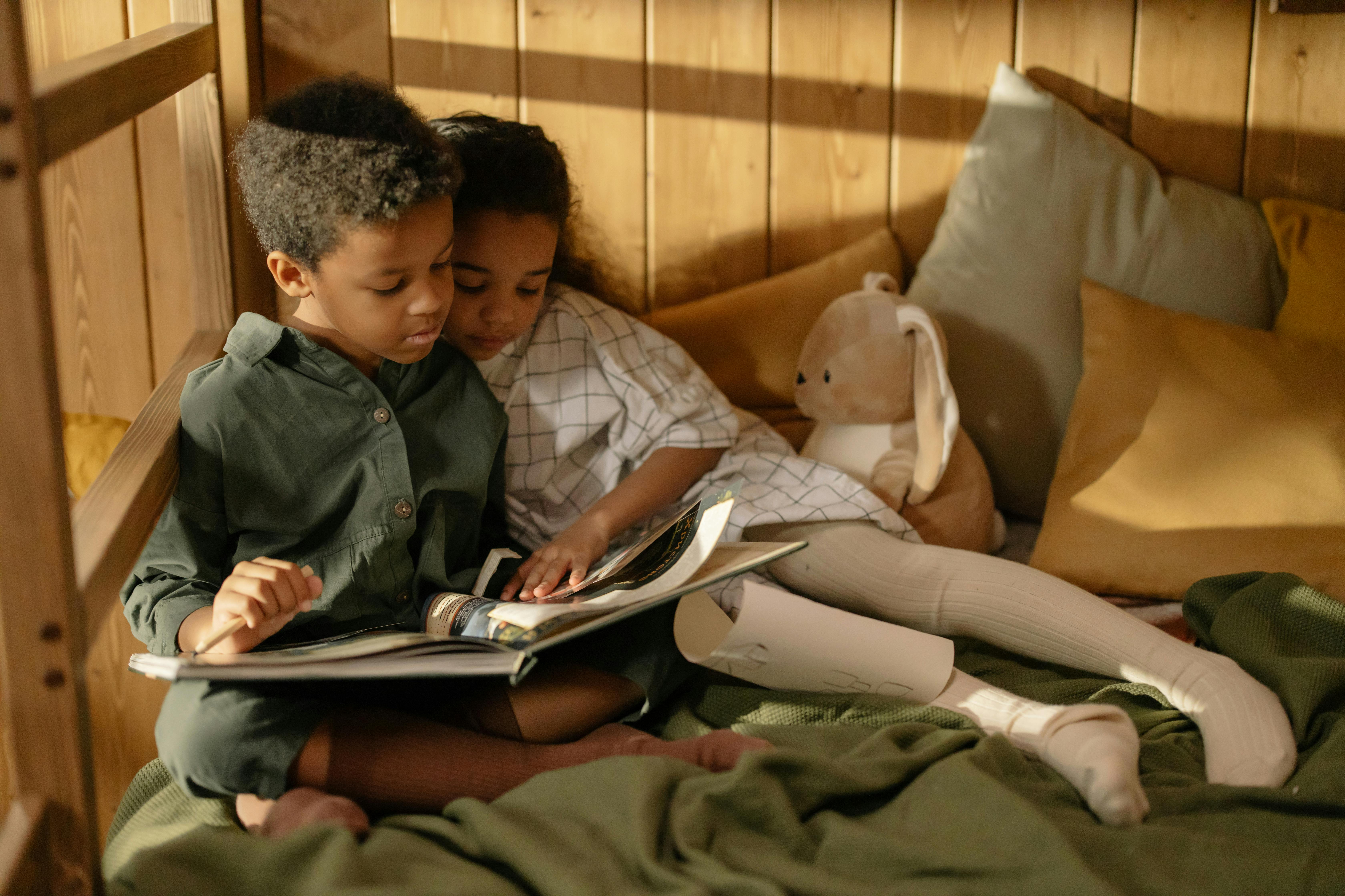 Two children reading a fairy tale book. | Photo: Pexels
