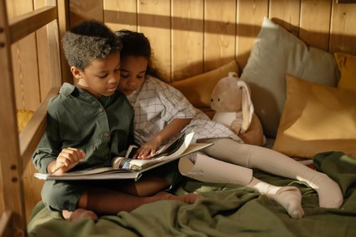 Free Two children reading together in a cozy room, capturing sibling love and togetherness. Stock Photo