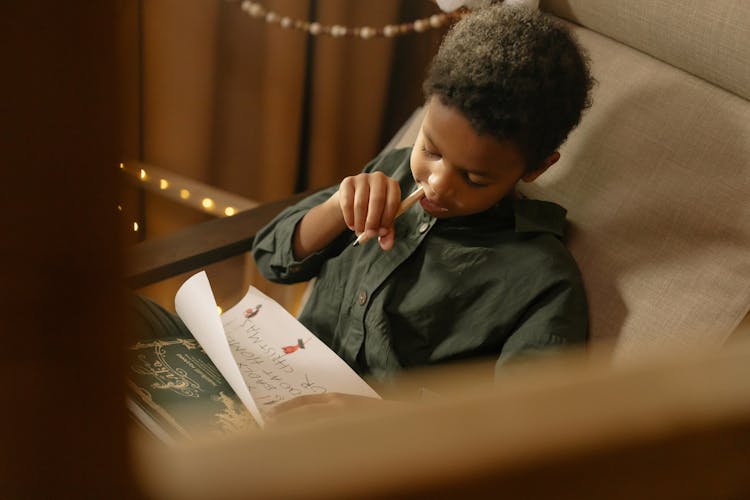 A Boy Writing On A Paper