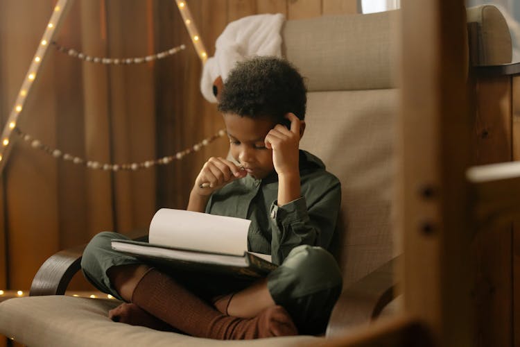 A Boy Writing On A Paper