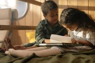 Boy in Black Jacket Reading Book