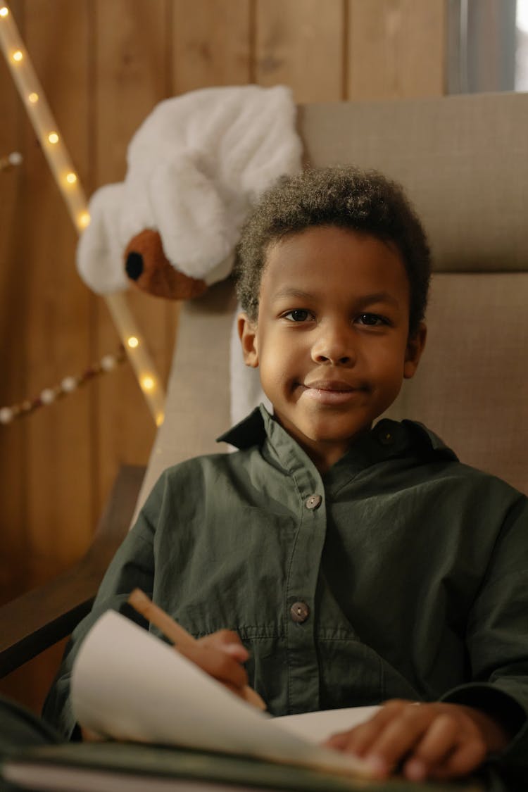 A Boy Writing On A Paper