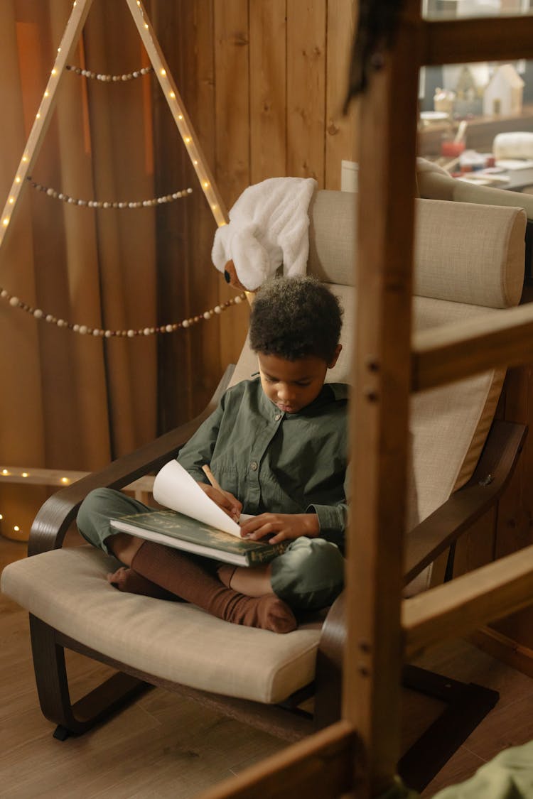 A Boy Writing On A Paper