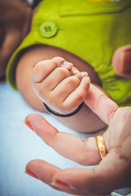 A Close-Up Shot of a Child Holding a Person's Finger
