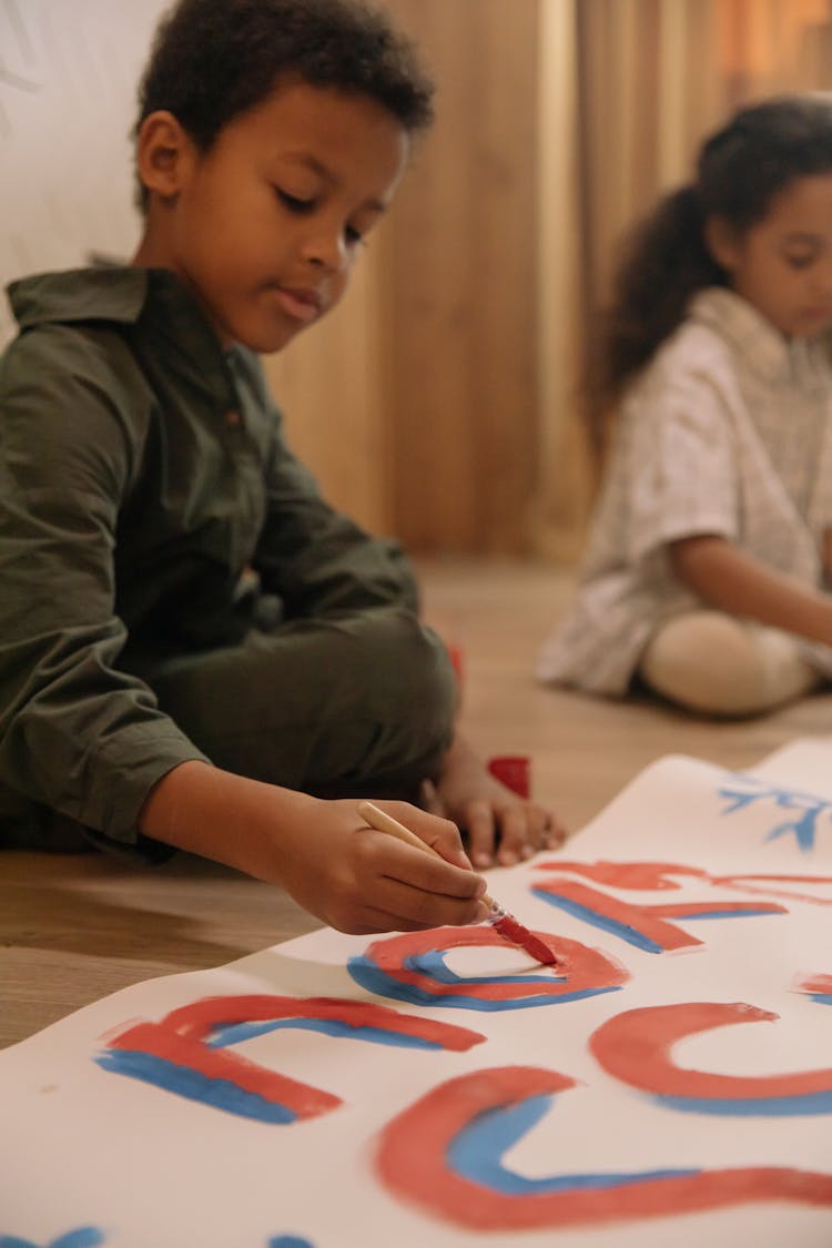 Boy Doing Painting On A Floor 