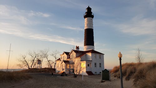 Free Lighthouse on Beach at Dusk Stock Photo