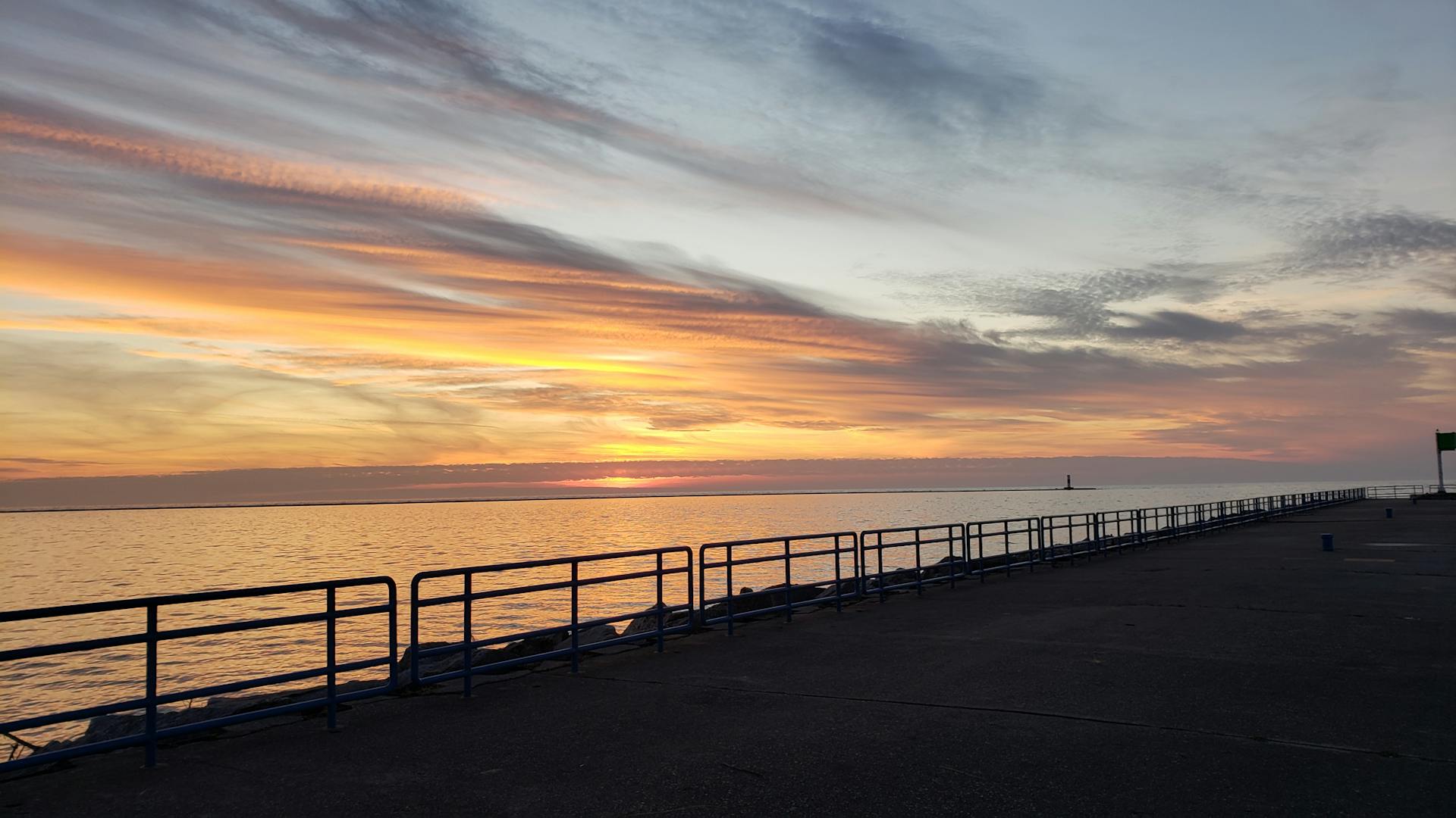 Breathtaking sunset view over Lake Michigan from Ludington pier with vibrant skies.