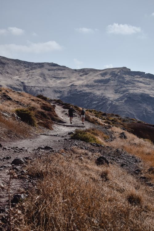 Free Hikers walking a scenic trail in Madeira's mountainous landscape. Stock Photo