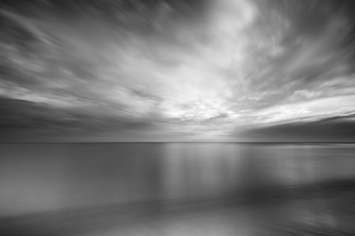 Free Black and white of dramatic vast ocean with calm water under gray cloudy sky Stock Photo