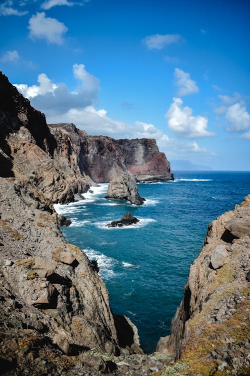 Montanha Rochosa Marrom Ao Lado Do Mar Azul Sob O Céu Azul