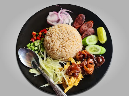 Cooked Rice With Sliced Cucumber and Sliced Meat on Black Ceramic Plate