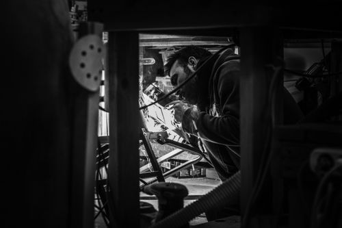Free A black and white image depicting a craftsman working meticulously in a workshop setting. Stock Photo