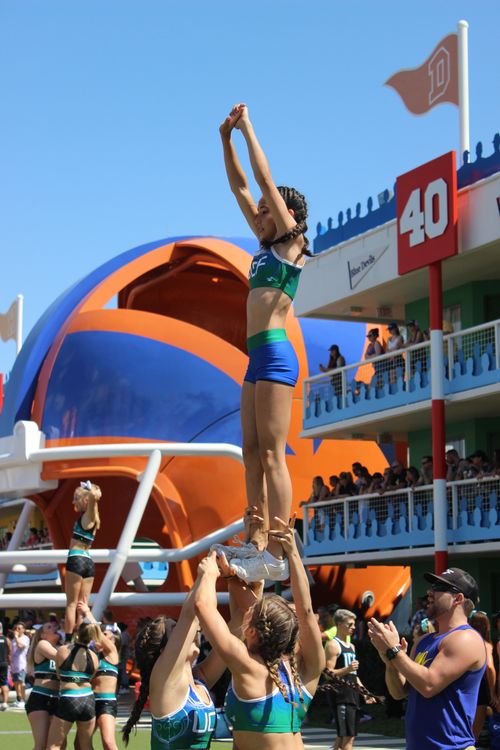 Free High-energy cheerleading stunt captured during a sunny day at an Orlando sports complex. Stock Photo