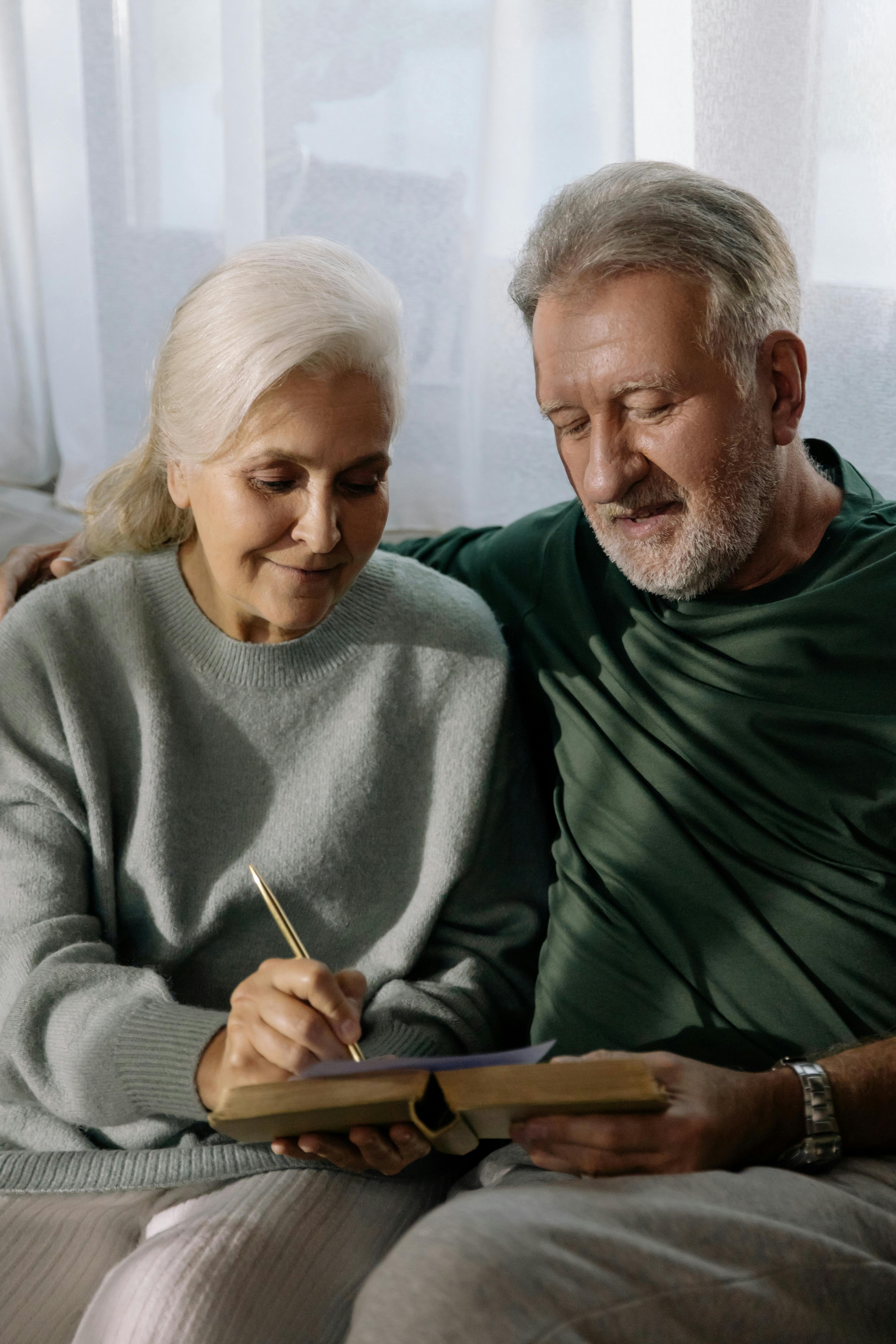 a woman in gray sweater sitting beside a man in green long sleeves